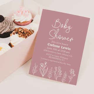 a box of cupcakes with a baby shower card