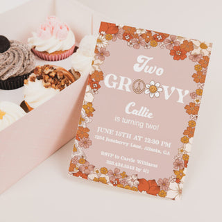 a pink box filled with cupcakes and a card
