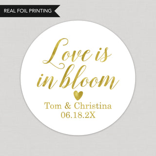 a round sticker with the words love is in bloom on it